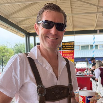 Tom Turney, wearing sunglasses and smiling outdoors